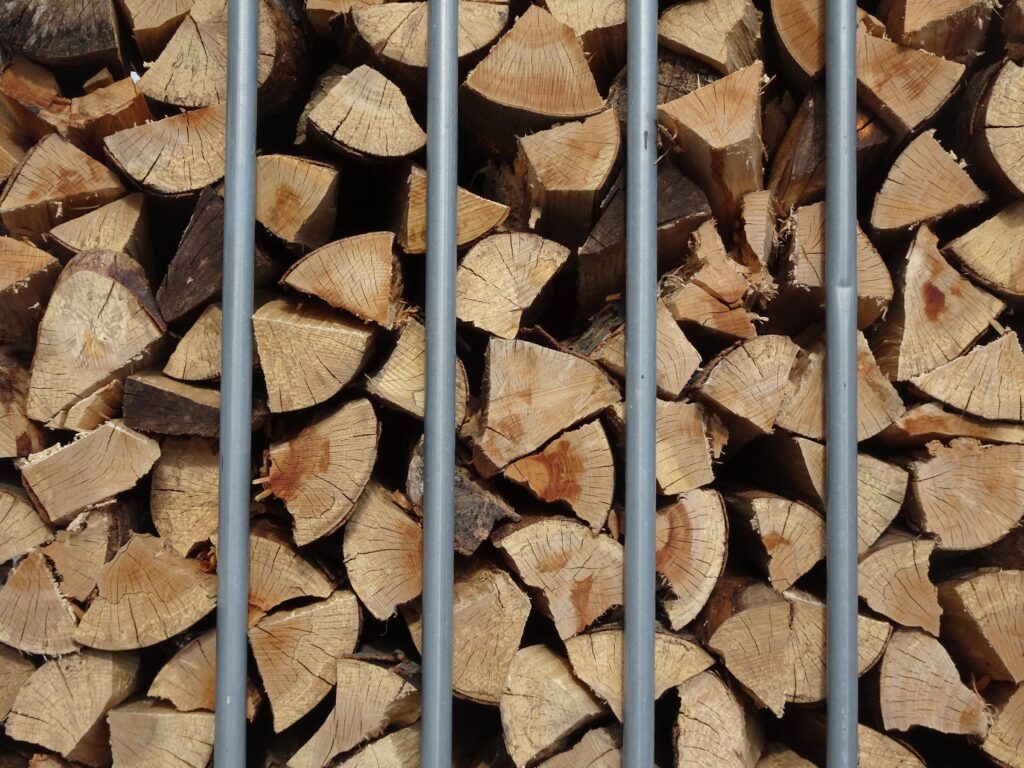 Gespaltene Scheite hinter den Stäben einer Gitterbox